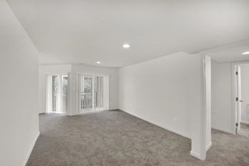 an empty living room with white walls and a white door